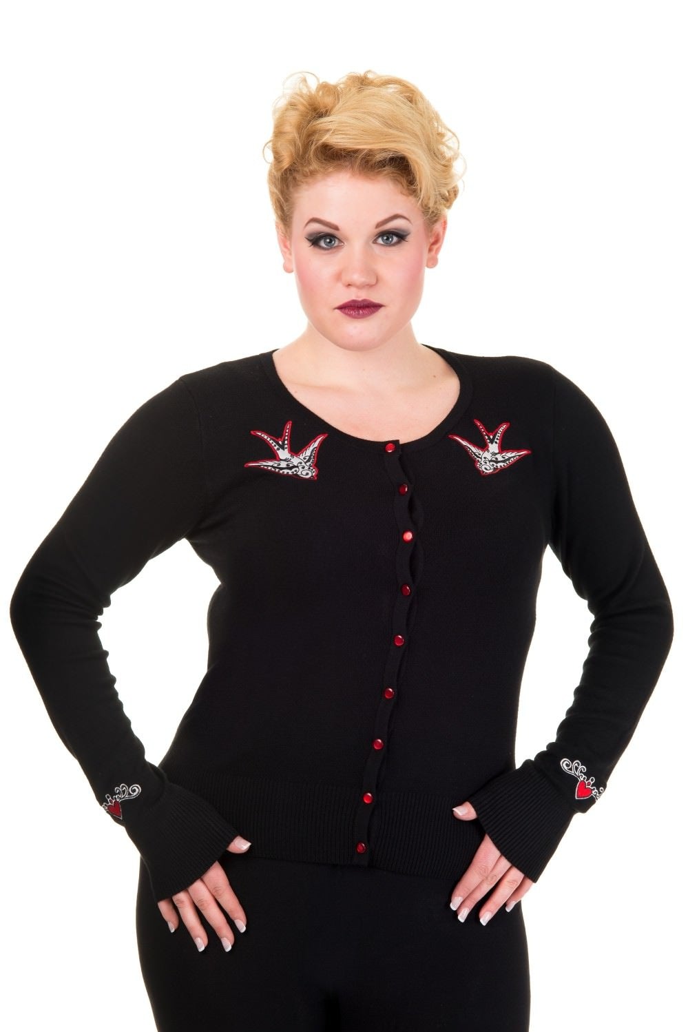 Model wearing black button up cardigan with red buttons and red swallow chest pieces.