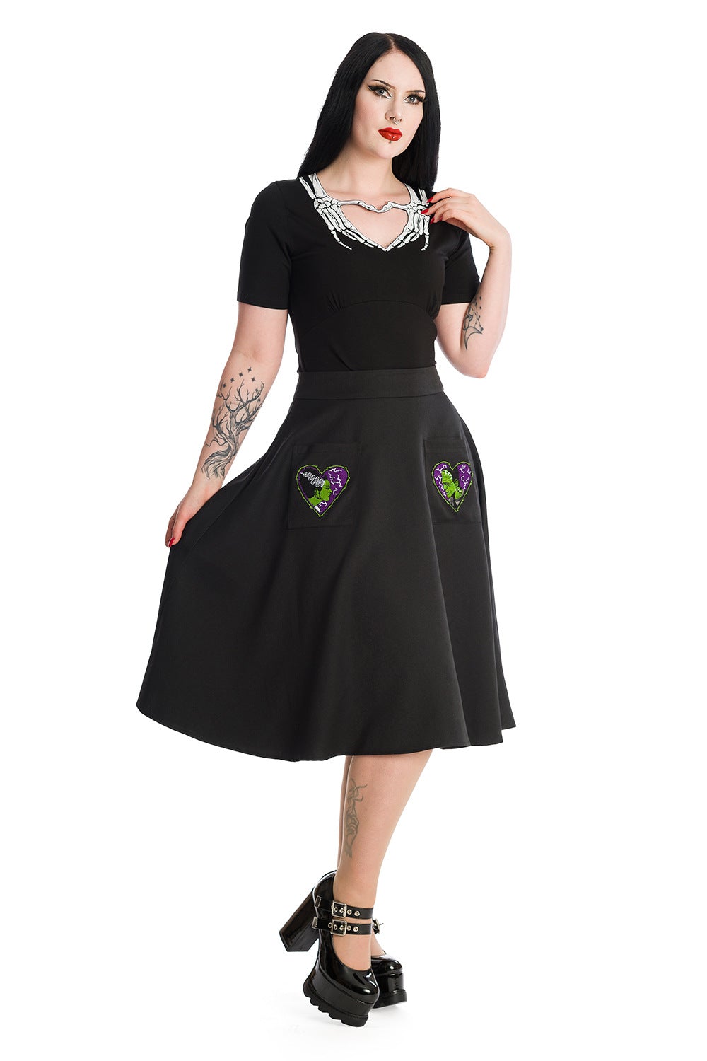 Alternative model wears short sleeve black top with skeleton hands around the collar creating a heart shape.