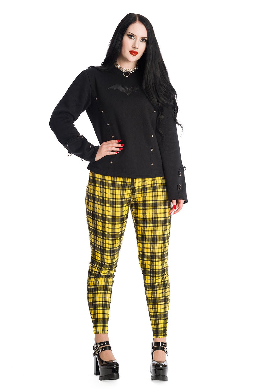 Alternative model wearing high waisted yellow check trousers with pentagram zip details.