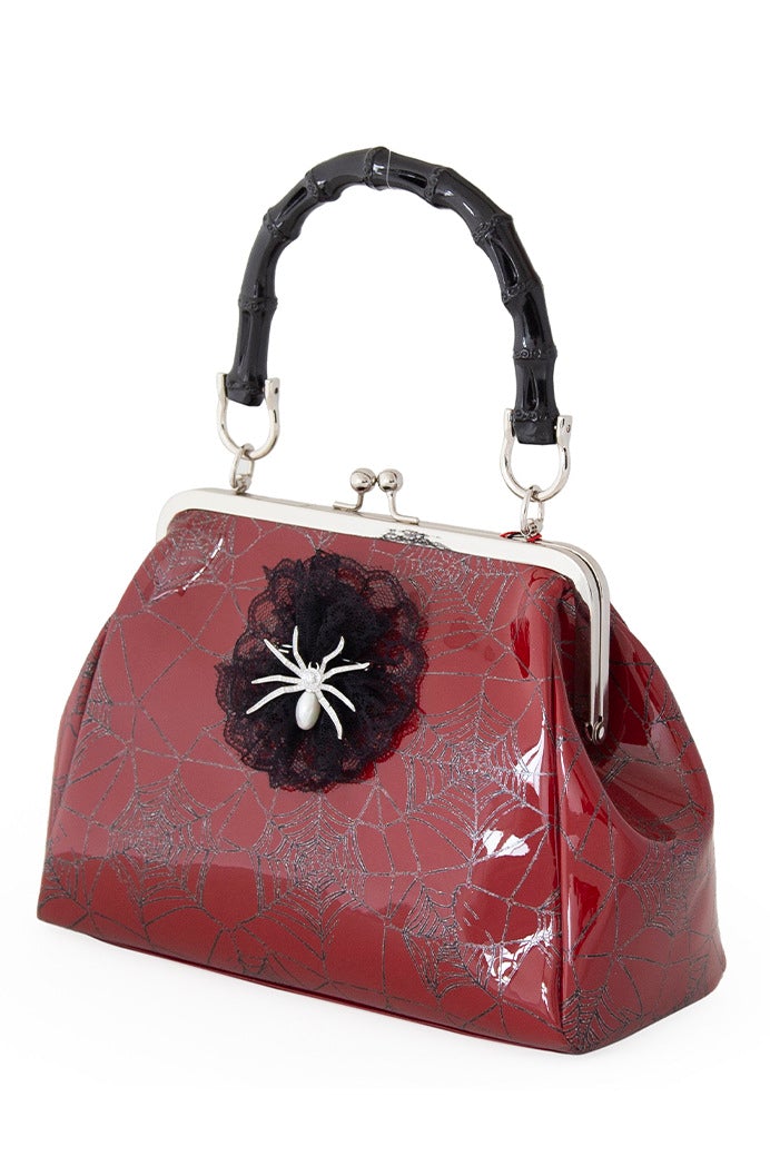 Red patent handbag with spider web print and spider detail