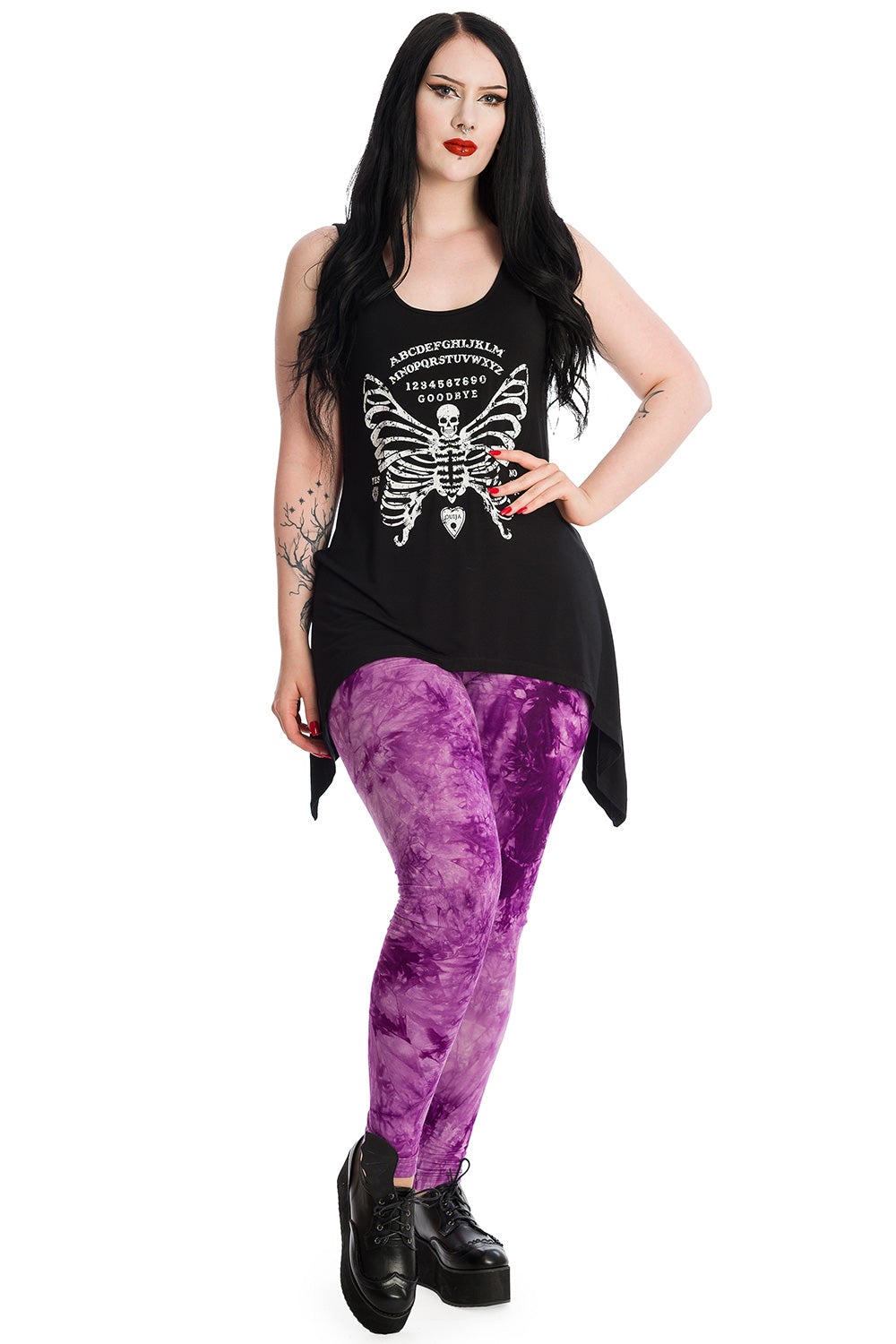Alternative model wearing long line vest top with skeleton butterfly print with ouija print.