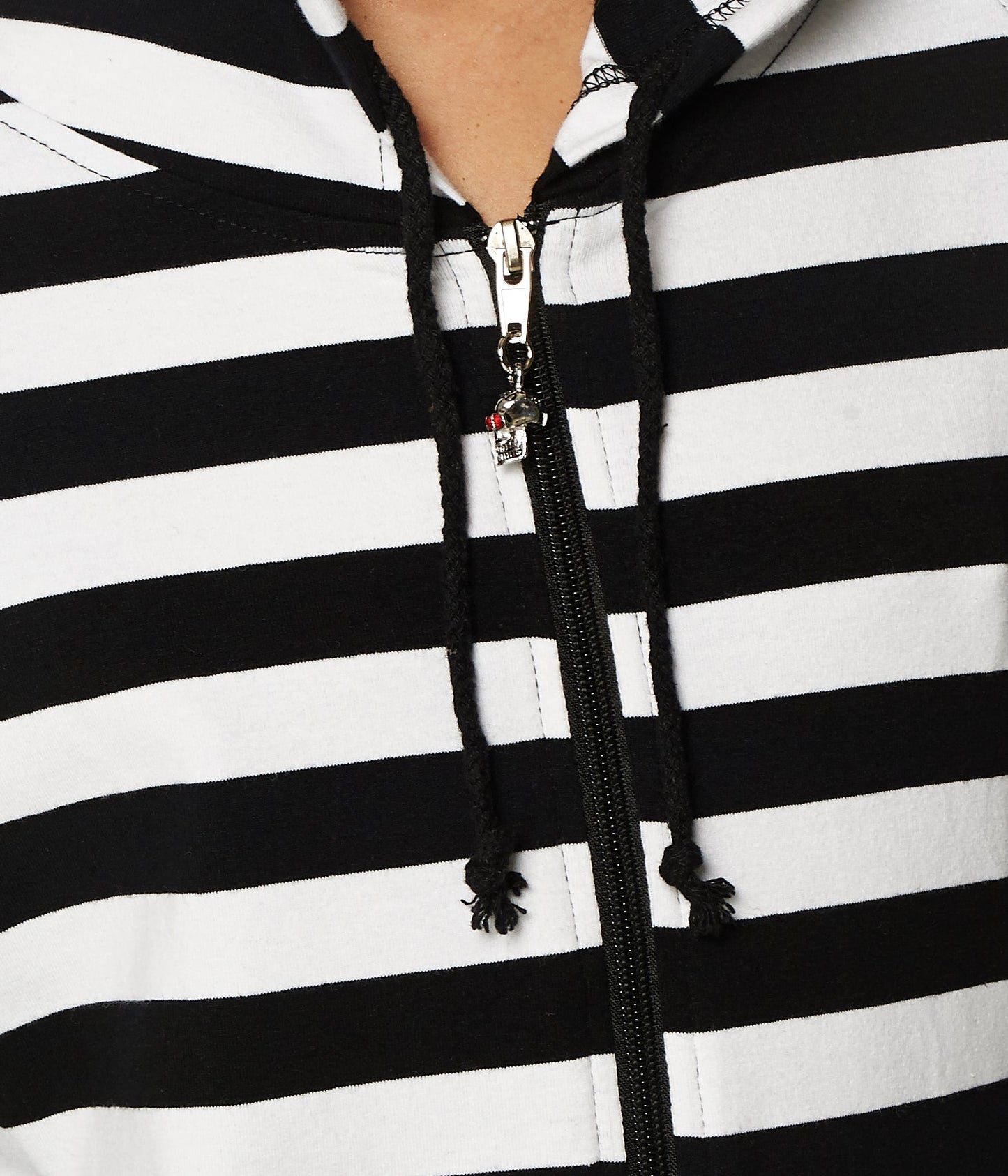 Close up of black and white striped hoodie with skull zip detailing.