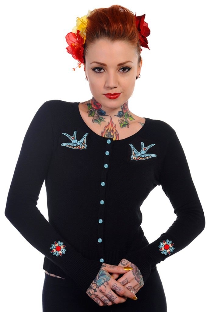 Model wearing black button up cardigan with blue buttons and blue swallow chest pieces.