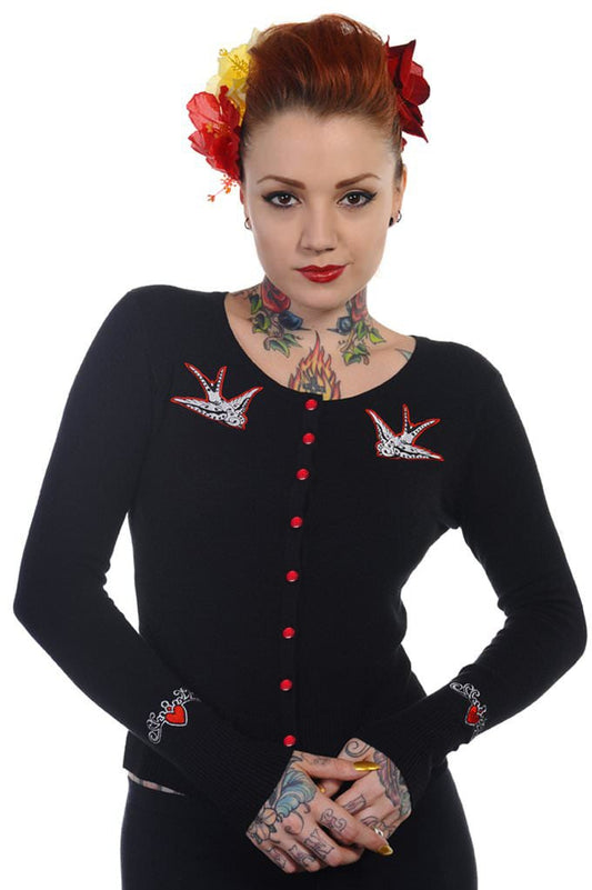 Model wearing black button up cardigan with red buttons and red swallow chest pieces.