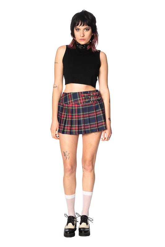 Alternative model in crop top and navy and red tartan mini skirt with buckles 