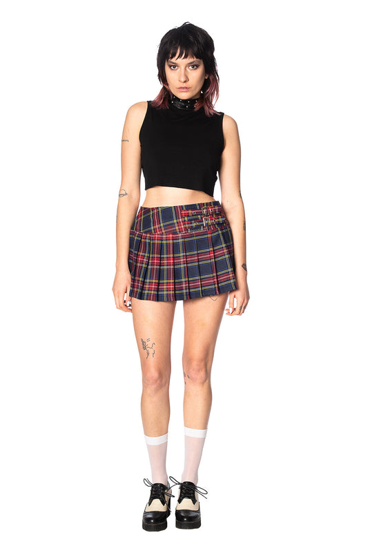 Alternative model in crop top and navy and red tartan mini skirt with buckles