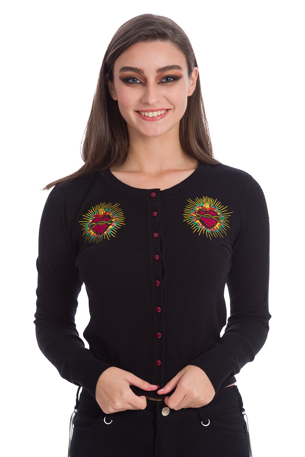 Model wearing black button up cardigan with embroidered red heart on either chest and red buttons. 