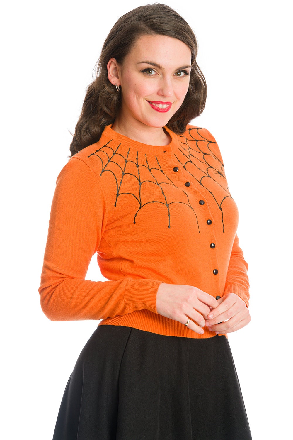Model in orange button up cardigan with black spider web shoulder details 