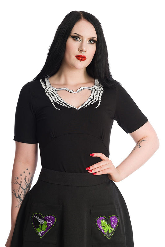 Alternative model wears short sleeve black top with skeleton hands around the collar creating a heart shape.
