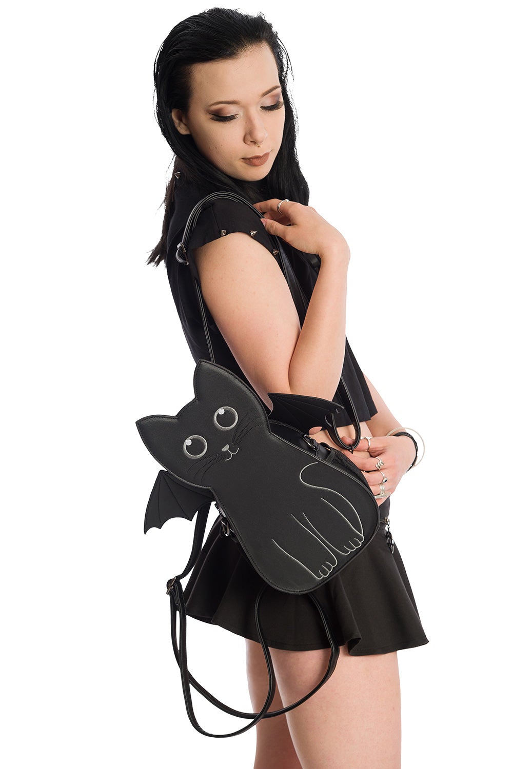 Model holding Cat shaped handbag with bat wings in black. 