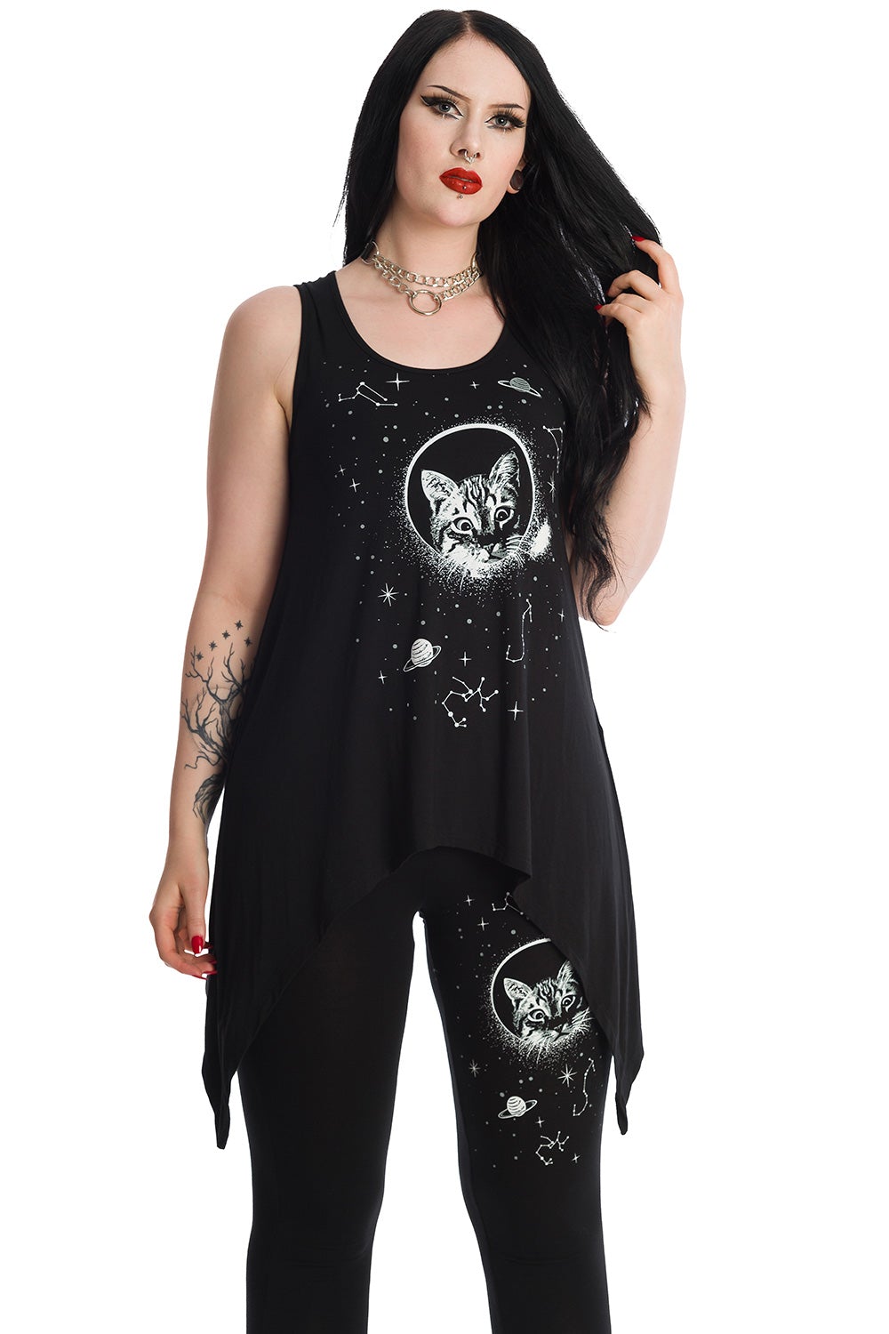 Alternative model wearing long line black vest top with space print and cat feature on the front. Model is wearing matching leggings. 