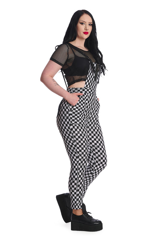 Alternative model wears black and white checkerboard dungarees with black mesh crop top underneath.