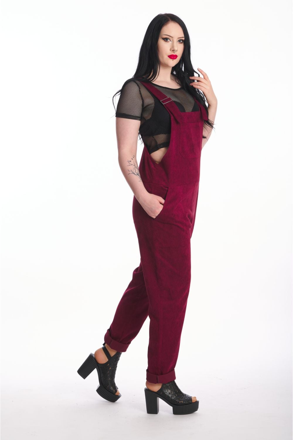 Alternative model in moss burgundy dungarees with black mesh crop top underneath. 