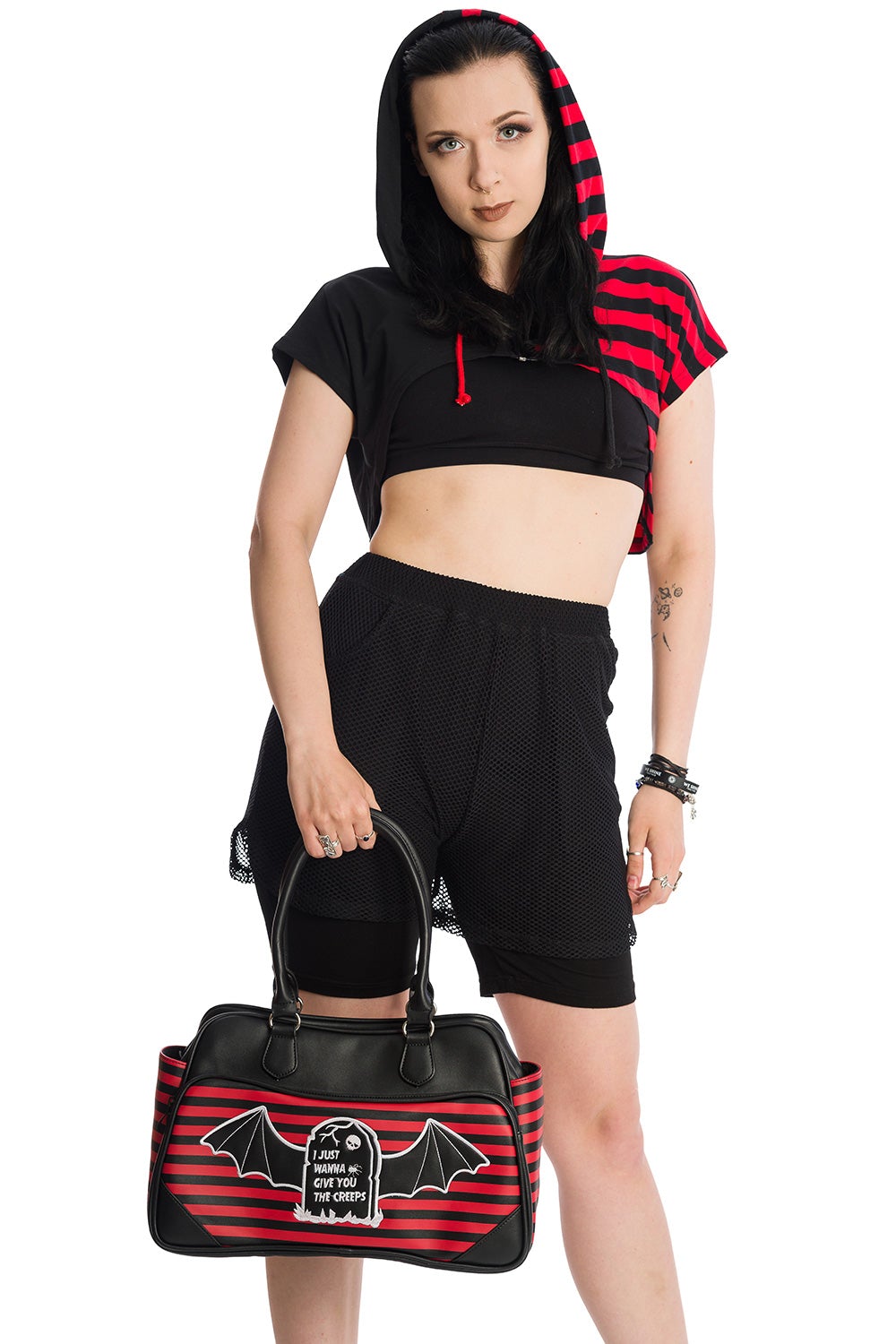 Alternative model in cropped half red strip and half black hoodie holding red striped handbag
