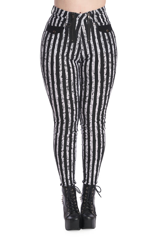 Alternative model in mesh black crop top with high waisted black and white striped skinny legged trousers with distressed colour.